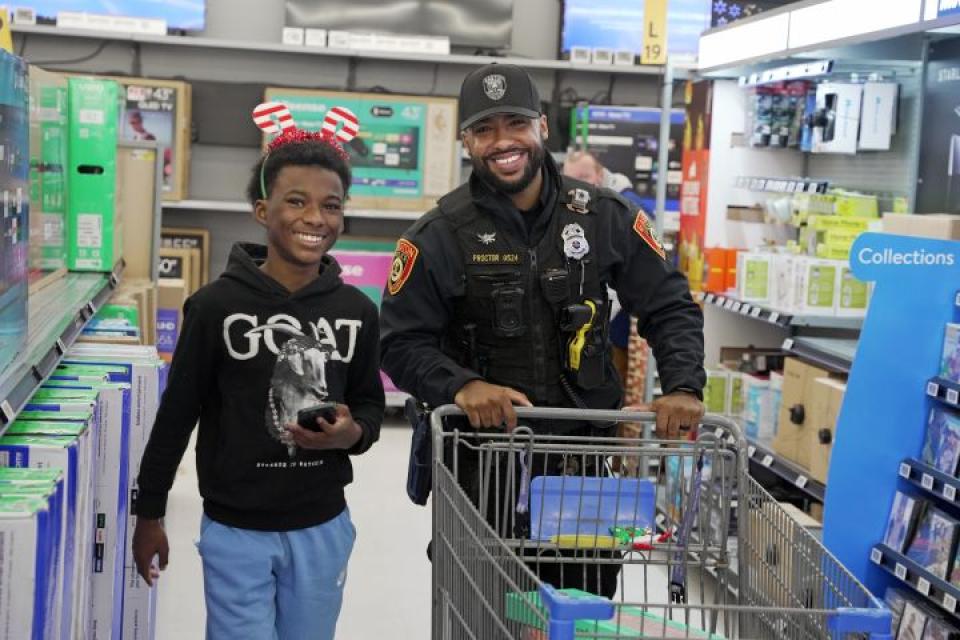 PFC Cordero Proctor from Easton Police Department helps a local youth from Talbot Mentors shop at Walmart for the Talbot Optimist Club's 'Shop With a Cop' event.