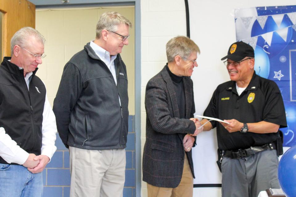 Council Vice President Pete Lesher hands Lt.Williams a card while County Manager Clay Stamp and Council Presidnet Chuck Callahan look on.