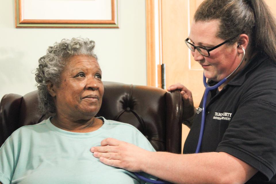 Catherine Stichberry, DES, checks heartbeat for patient during MIH appointment.