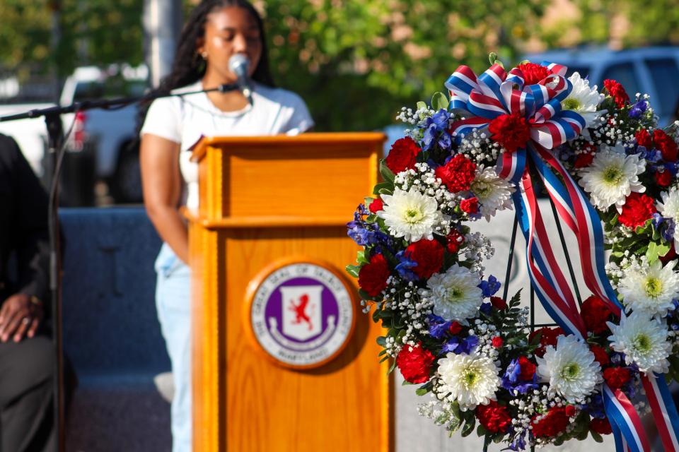 Ta’Vea Roberts, student at Easton High School, sings “America the Beautiful” behind the memorial wreath.