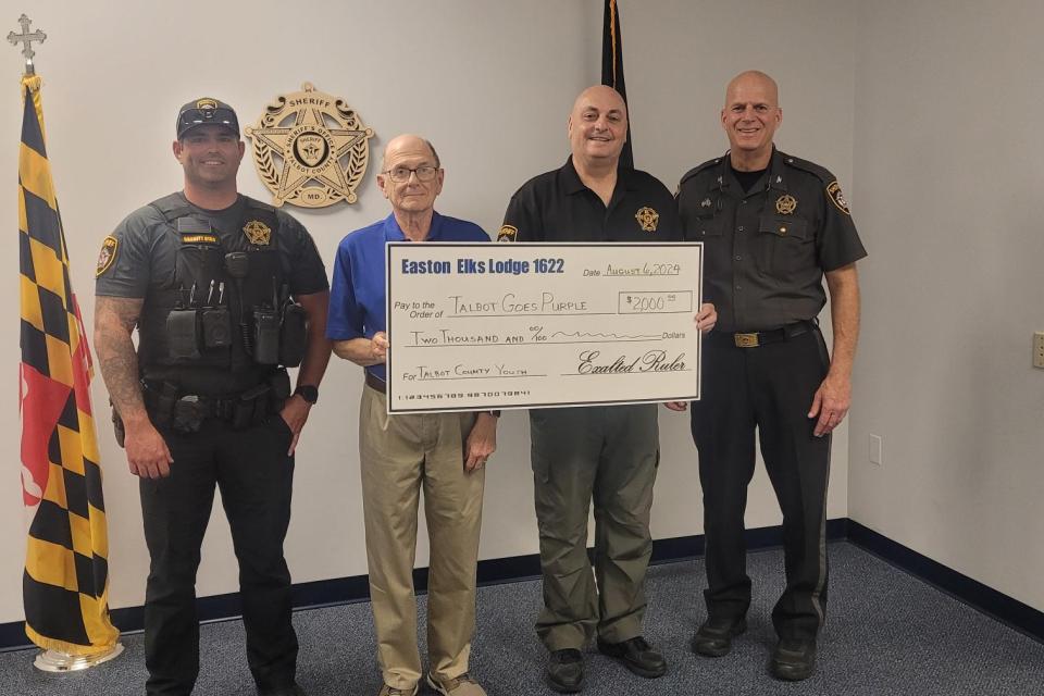 Cutline: Talbot County Sheriff Joe Gamble, far right; Major Steve Elliott, second to right, and DFC William Barnett, far left, stand with Easton Elks Exalted Ruler Mel Newell as he presents a donation from Easton Elks Lodge #1622.