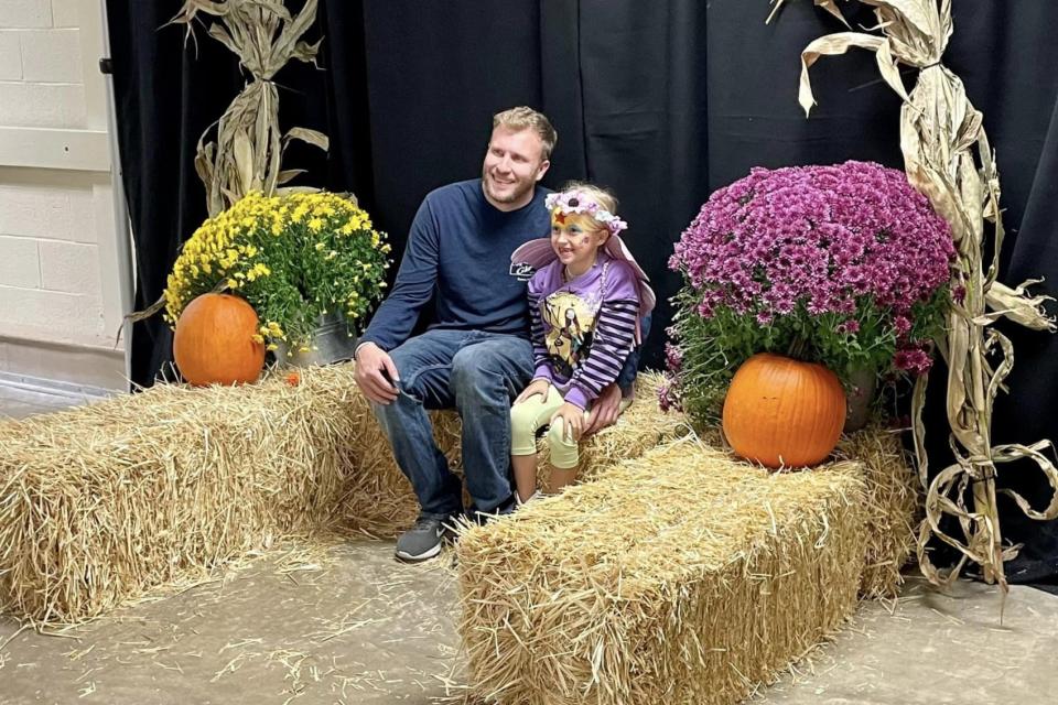 Father and child get their photo taken at the fall-themed photo booth at 2023 Boonanza.